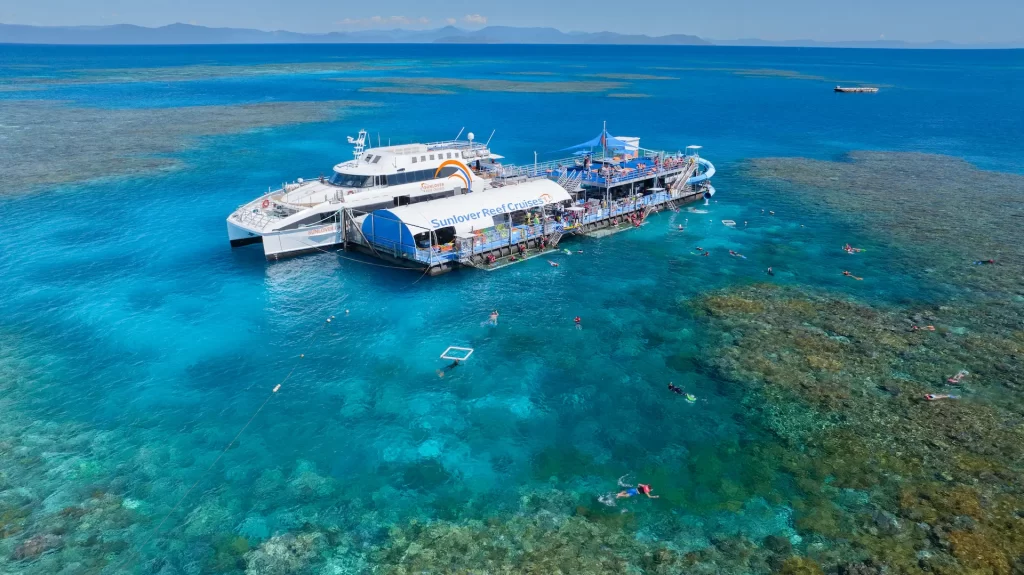 Sunlover Reef Cruises Moore Reef Pontoon Great Barrier Reef Cairn Aerial view of Sunlover Reef Cruises pontoon at Moore Reef on the Great Barrier Reef, with snorkellers exploring the coral reef from Cairns