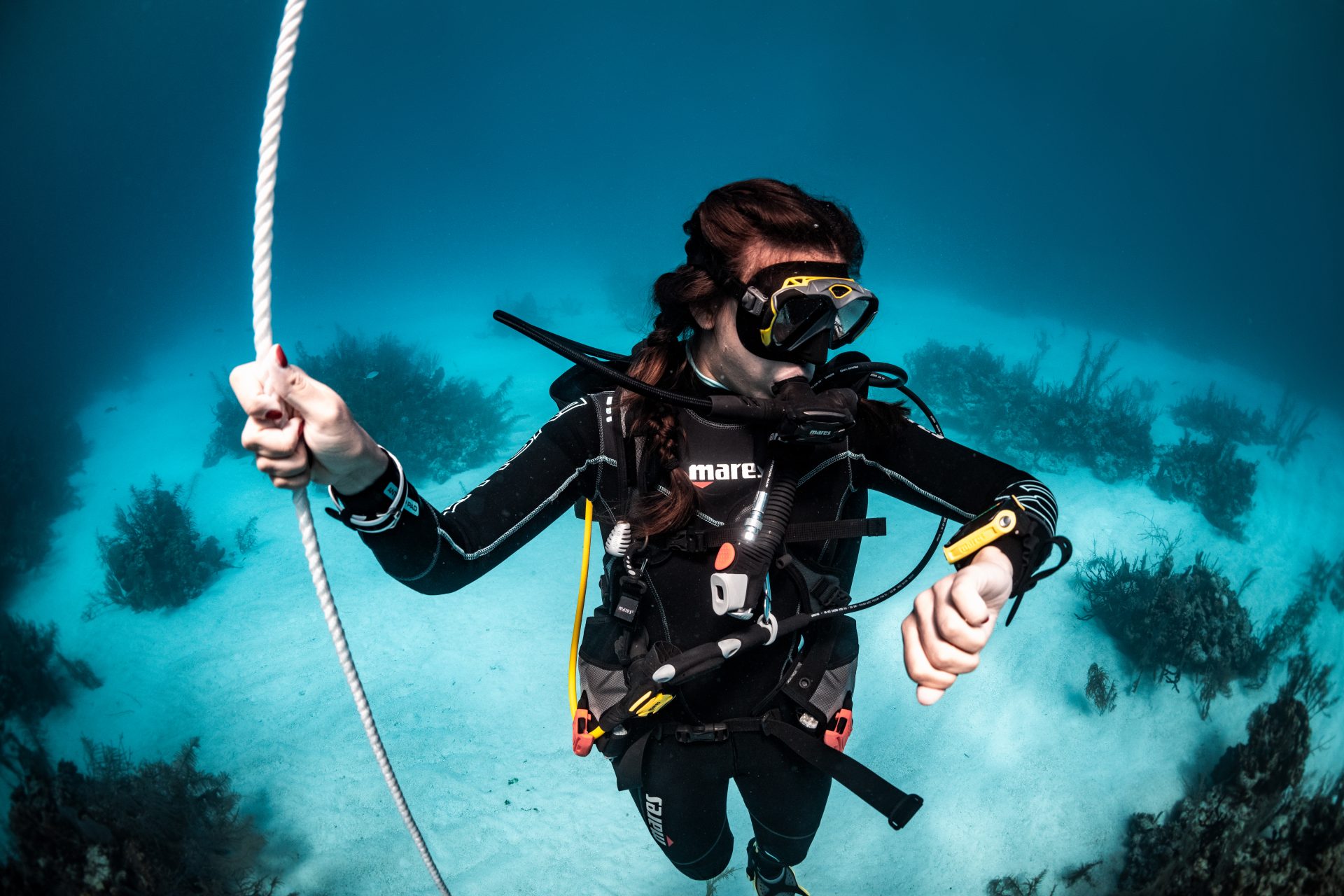 Scuba student monitoring their ascent rate on a controlled ascent line during training