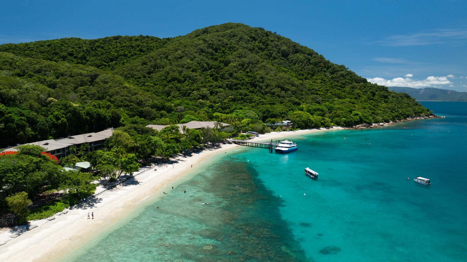 Aerial view of Welcome Bay at Fitzroy Island with a white coral beach, turquoise water and fringing reef